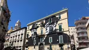 Colorful building in Naples’ Sanità district decorated with large street art murals, a highlight of the guided walking and food tour
