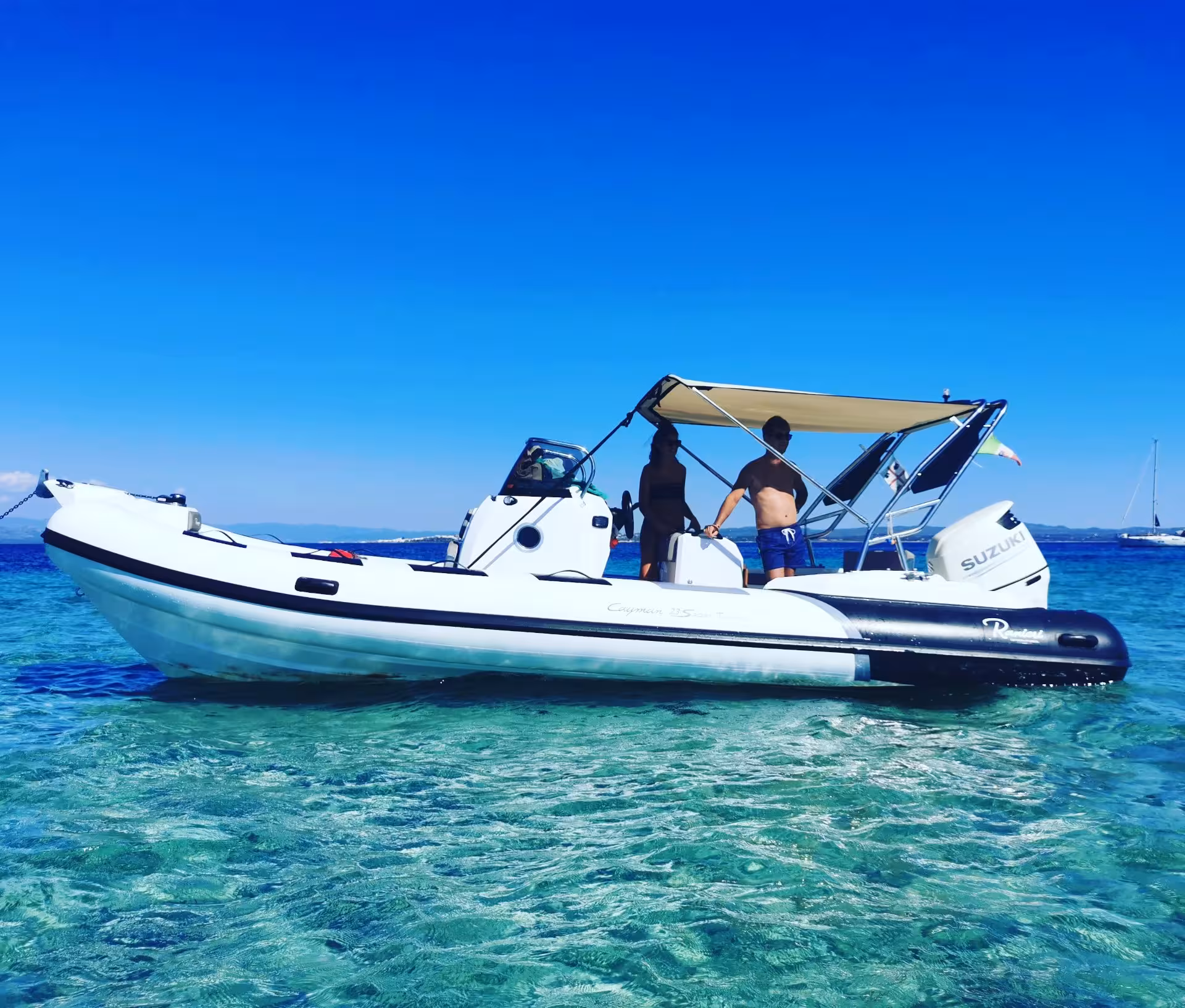 A white RIB boat anchored in clear blue waters during a Sant'Antioco 4-hour tour under a sunny sky.
