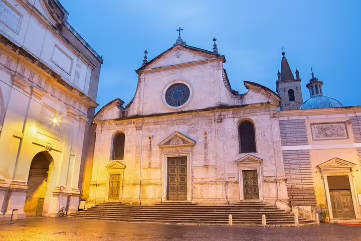 Facade of Santa Maria del Popolo at dusk on a Rome Caravaggio and Baroque masterpieces private guided walking tour