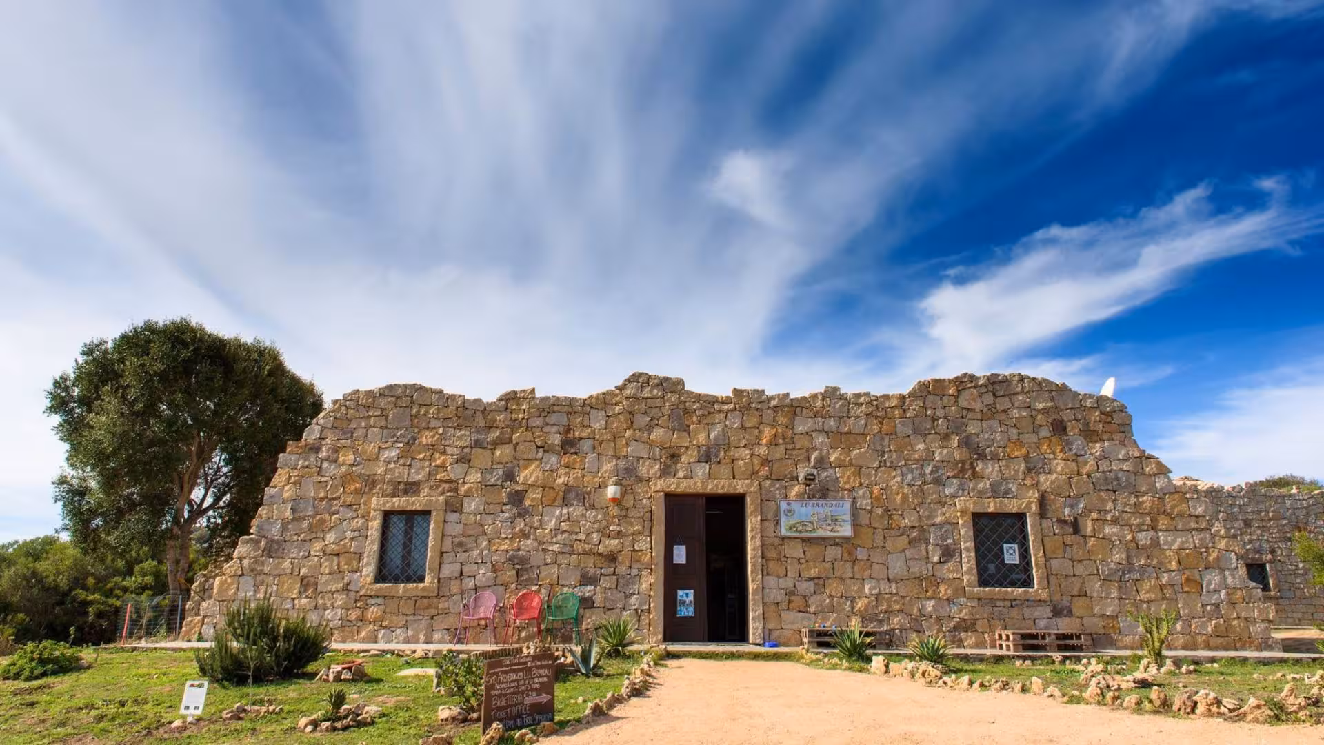 Stone building under a clear blue sky at Santa Teresa Gallura, showcasing ancient architecture and cultural heritage.