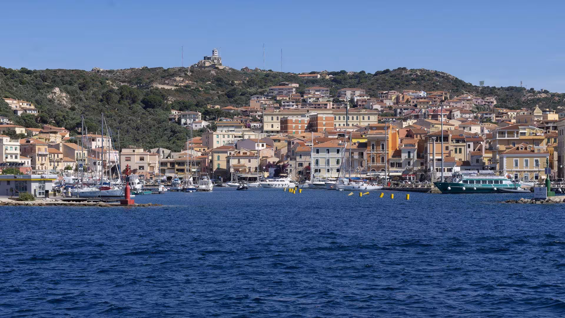 Panoramic view of Santa Teresa di Gallura port with colorful buildings and yachts, ideal for La Maddalena Archipelago tours.
