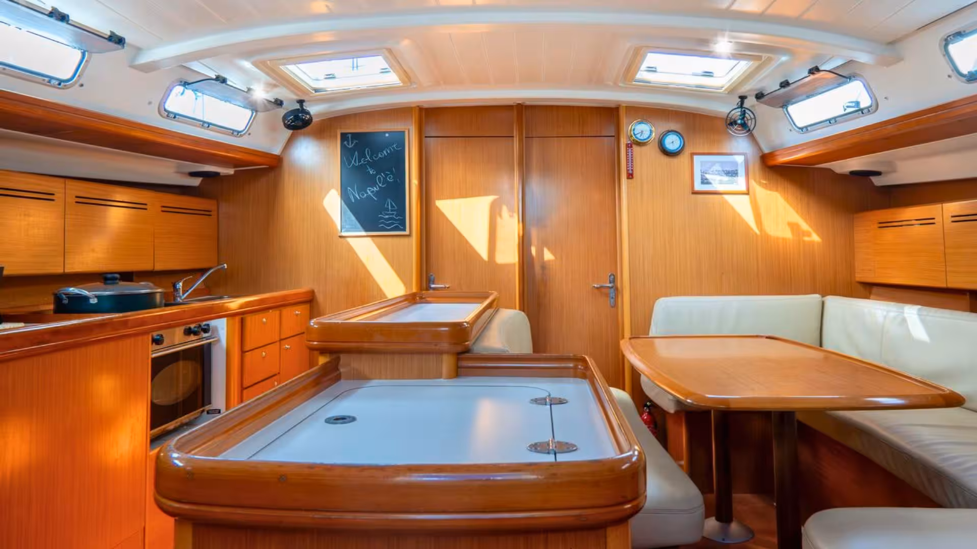 Spacious and sunlit sailboat cabin with dining and kitchen facilities for Corsica sailing adventure from Santa Teresa di Gallura.