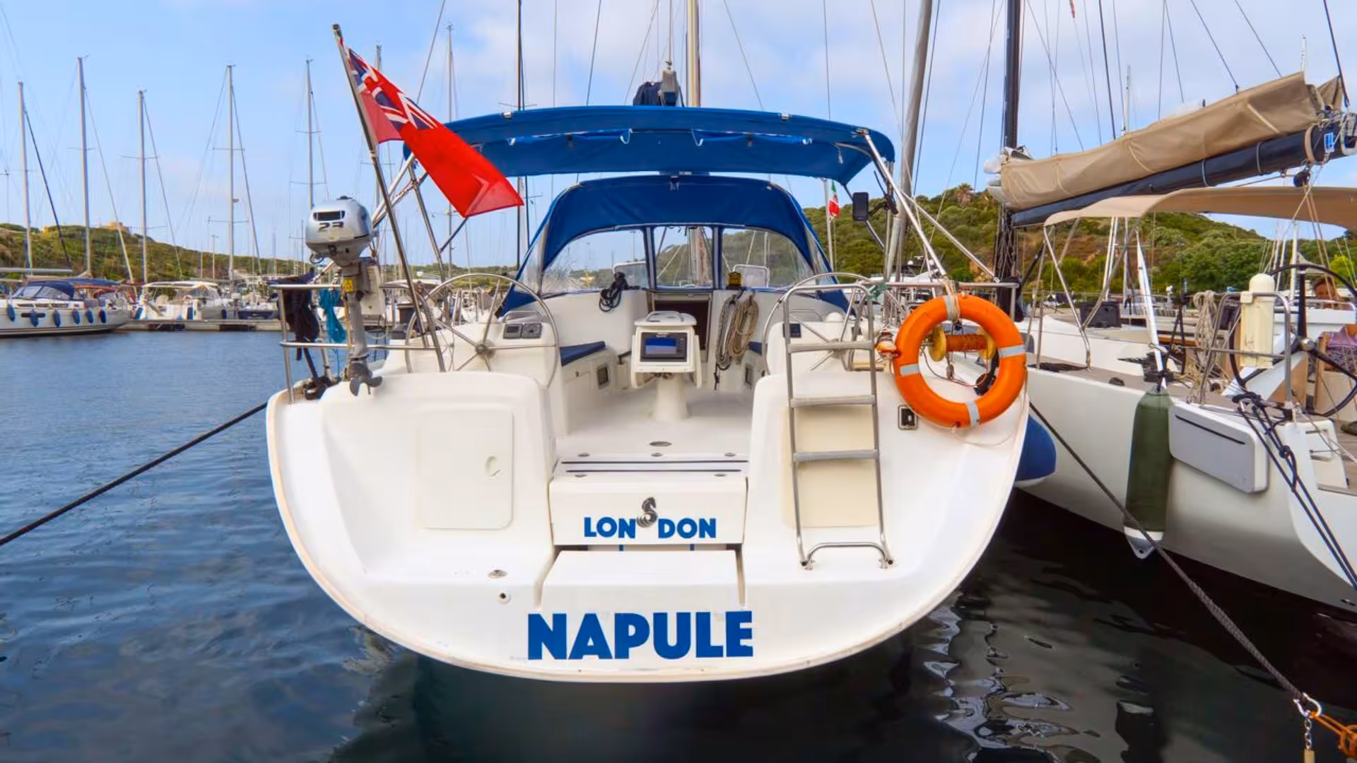 Docked sailboat with blue canopy ready for Santa Teresa di Gallura to Corsica sailing trip.