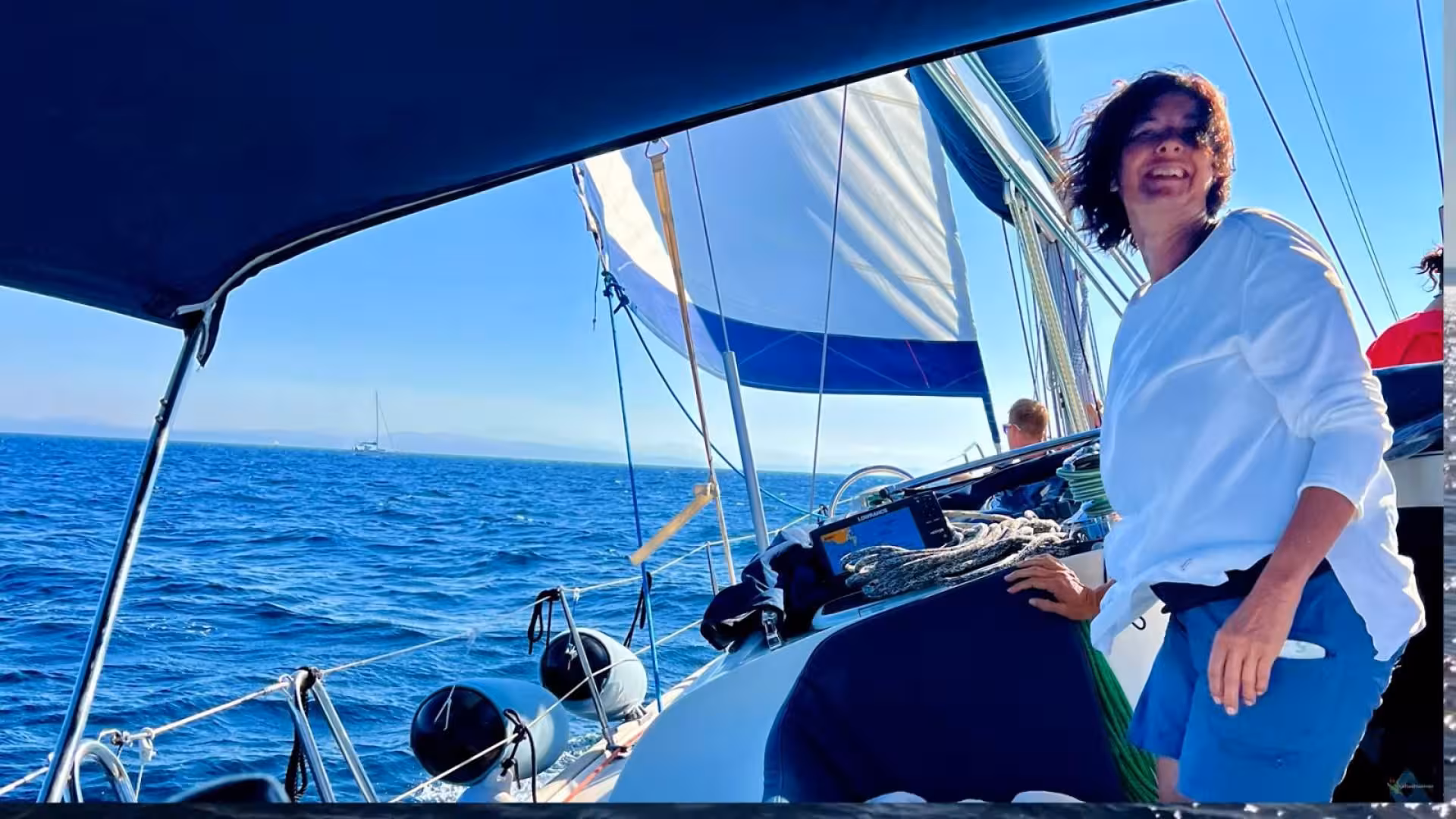 Sailing adventure from Santa Teresa di Gallura to Corsica with a smiling woman enjoying the sea breeze.