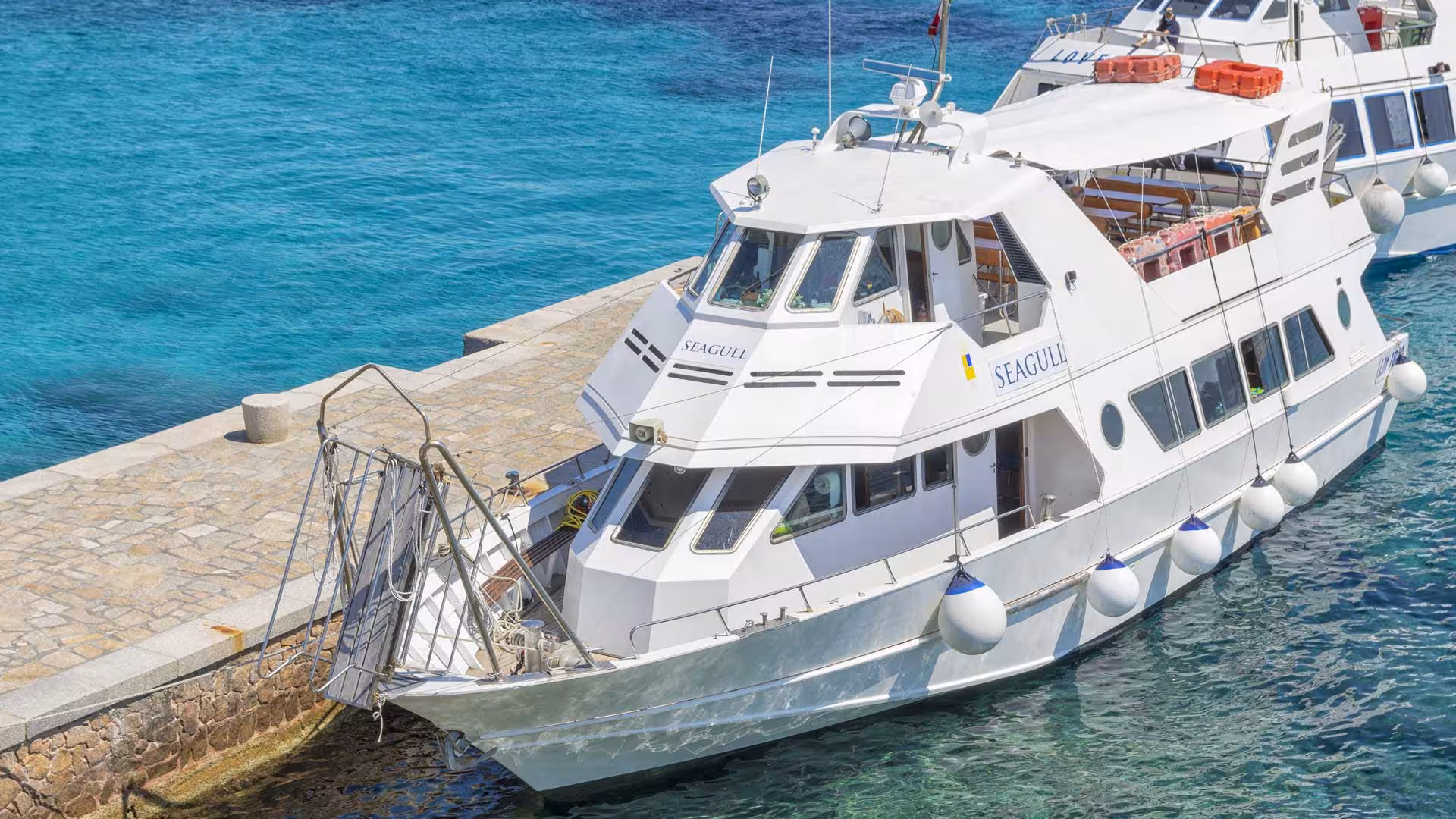 Motorboat docked at Santa Teresa di Gallura, ready for La Maddalena Archipelago tour with crystal-clear waters.