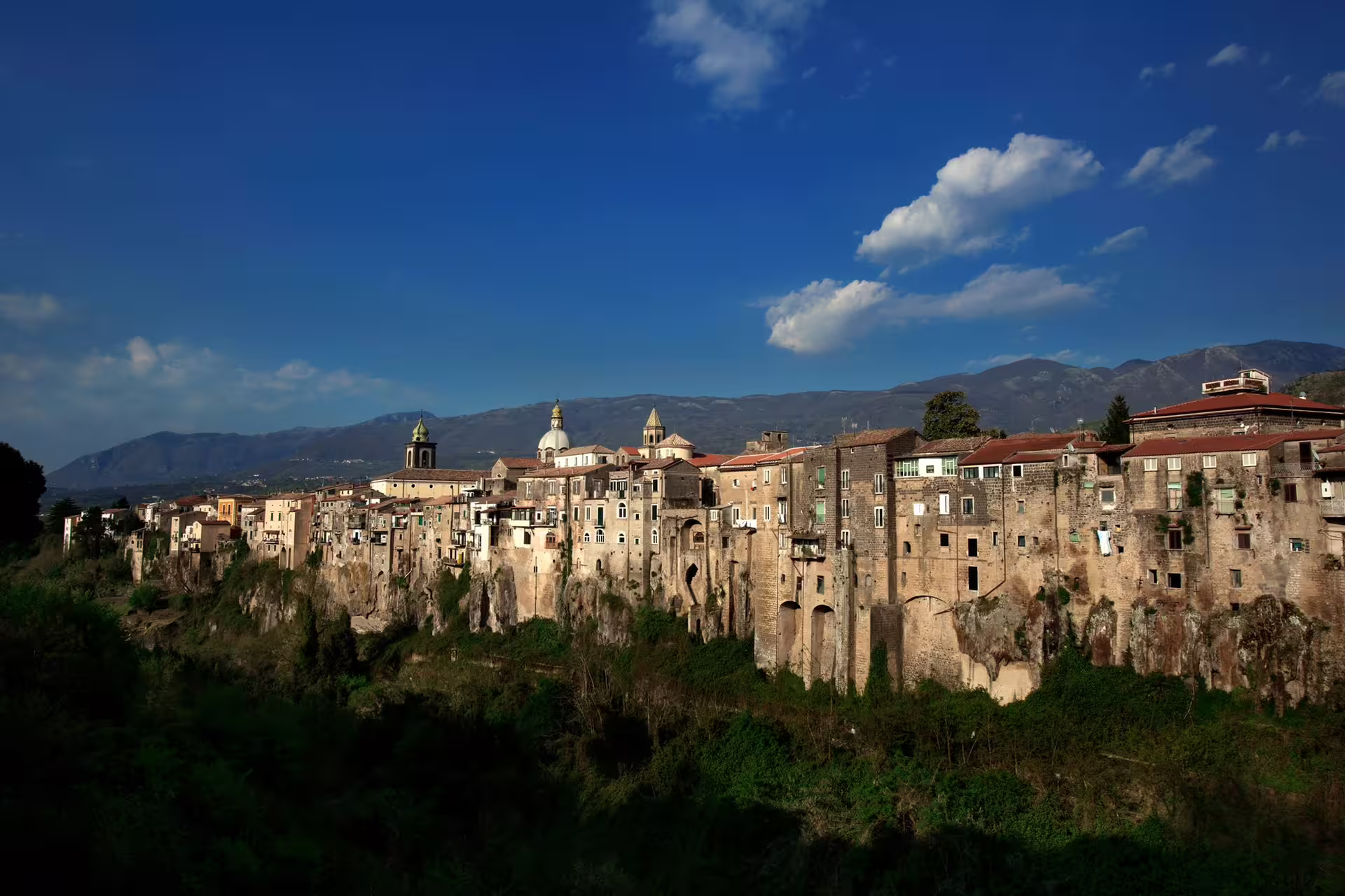 Historic cliffside houses of Sant’Agata de’ Goti in Campania, Italy, viewed from the valley on a clear wine tour day
