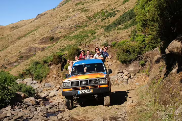 Adventurers enjoy a thrilling Santana Northeast 4x4 tour, exploring rugged terrains and lush landscapes in a vibrant off-road vehicle.