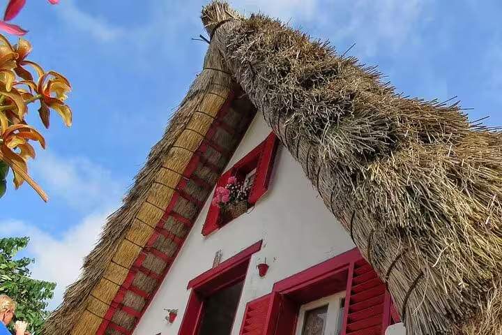 Traditional Santana house with a thatched roof under a clear blue sky on the Full Day Santana Wonders and Northeast 4WD Experience.