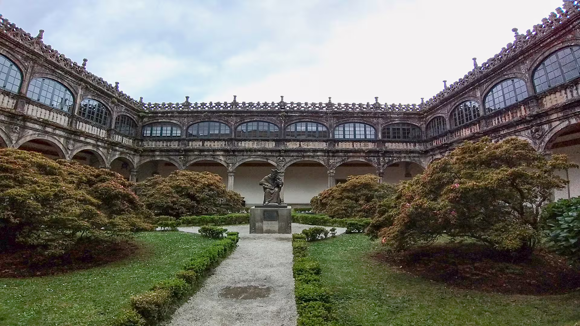 Historic courtyard with manicured gardens and a statue at Santiago de Compostela, perfect for a private cathedral tour experience.