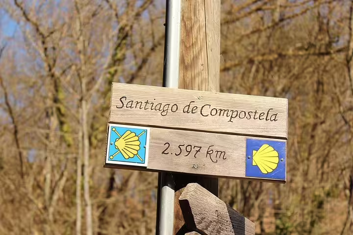 Wooden signpost indicating 2.597 km to Santiago de Compostela, marking a notable point on the full day tour.