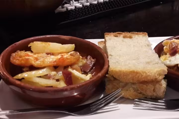 Santiago Old Town tapas tour featuring baked potatoes with bread slices and forks.