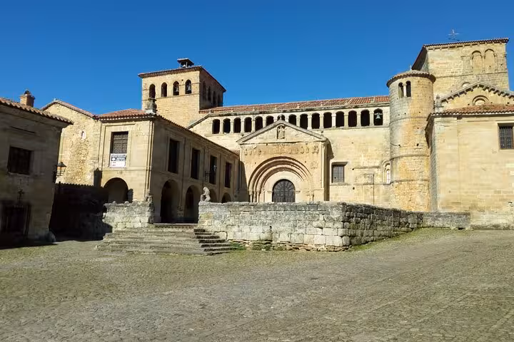 The historic Collegiate Church of Santillana del Mar under a clear sky, a key attraction on the Santander tour.