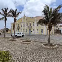 Historic colonial building with palm trees and cobblestone square in Santo Antão, seen during an 11-hour São Vicente day trip by car.