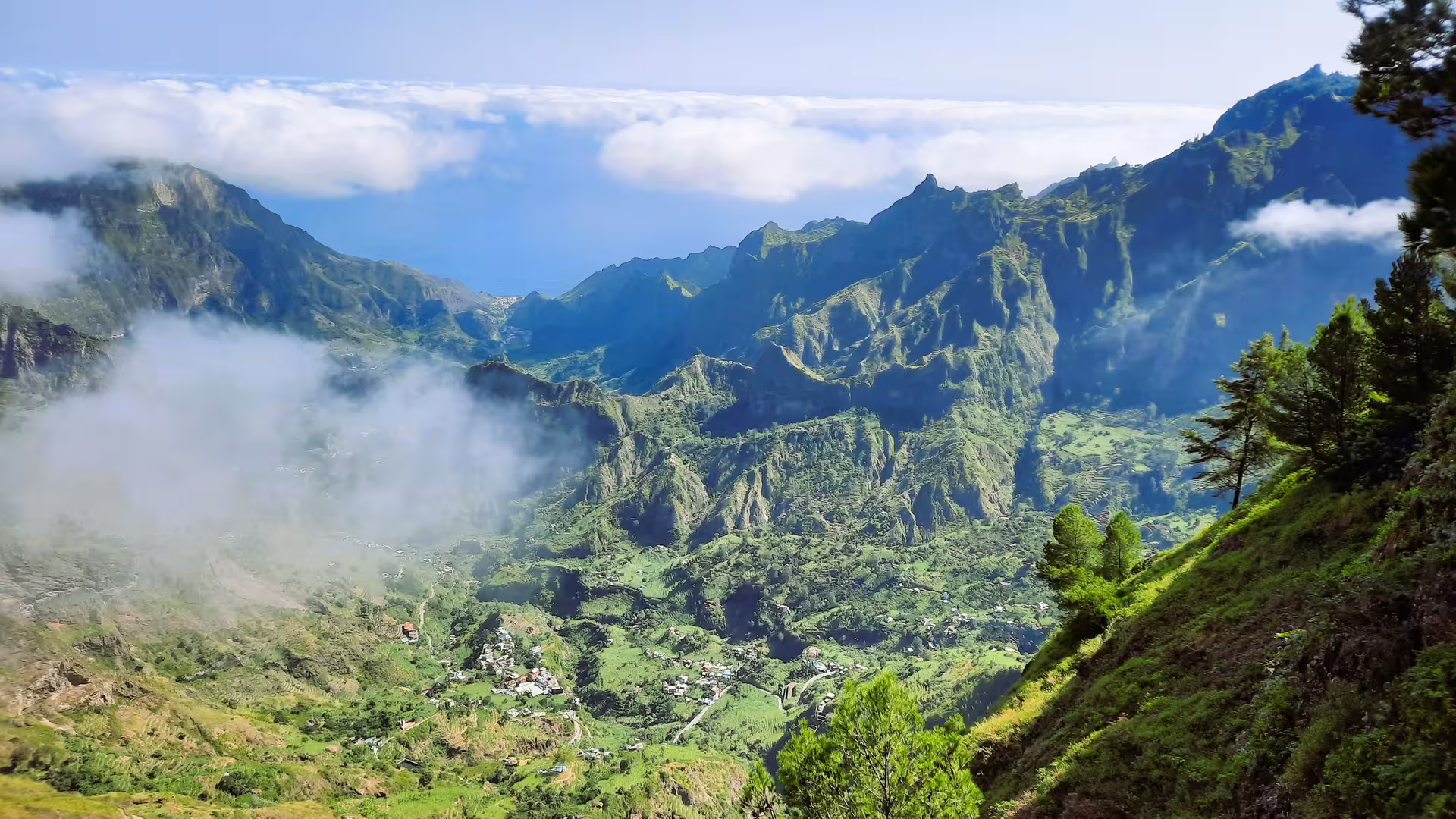 Breathtaking view of Santo Antão's Cova de Paúl volcanic crater with lush green valleys and misty clouds.