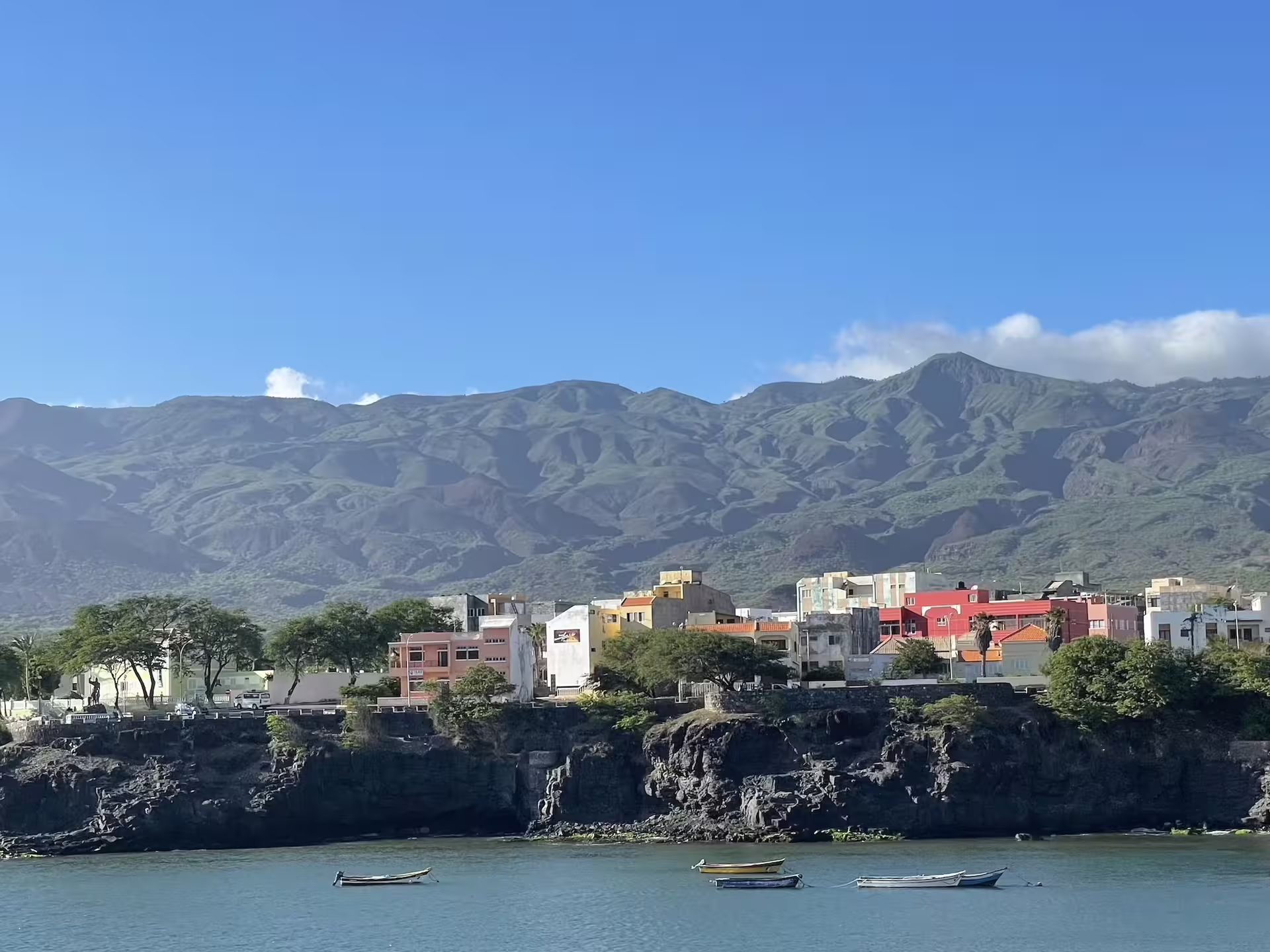 Scenic view of Santo Antão's lush mountains and colorful coastal village, captured during a day trip from São Vicente.