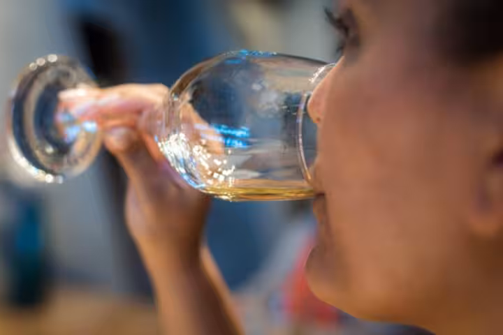 Cruise guest tasting Santorini Assyrtiko wine during Five Senses winery experience and village tour