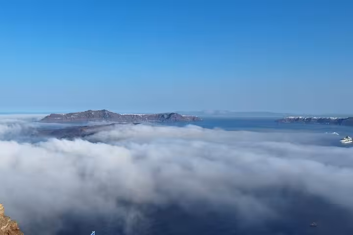 Panoramic Santorini caldera and Aegean Sea above clouds, scenic viewpoint on luxury villa day getaway