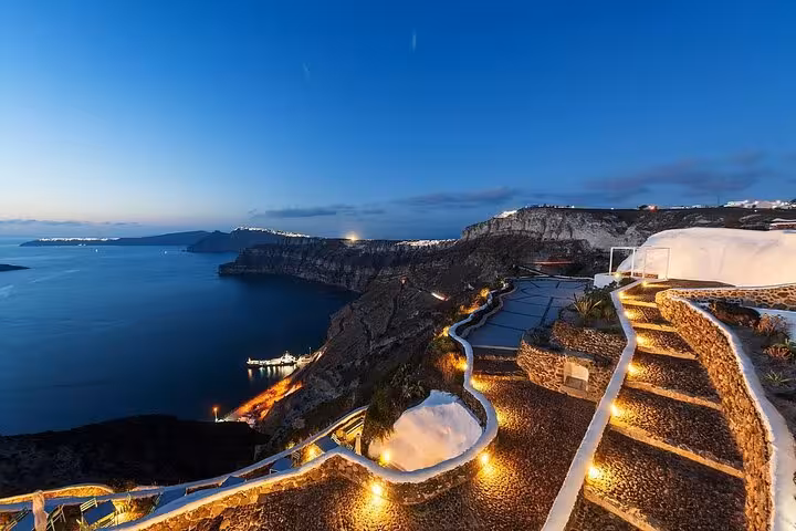 Santorini caldera at dusk with cliffside paths and sea views on a 7-day private Athens island tour