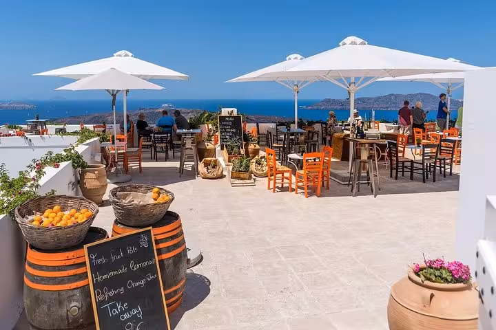 Santorini caldera-view terrace café stop on a private half-day sightseeing tour with Oia scenery