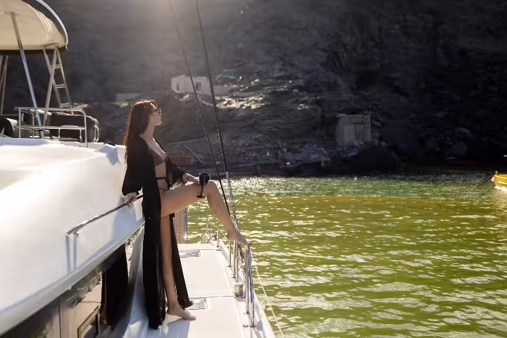Relaxed passenger enjoying the sun on a premium Santorini catamaran cruise.