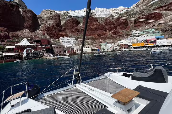View from a catamaran of Santorini's vibrant port and iconic cliffs, perfect for a tailor-made Greek island adventure.