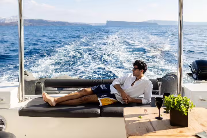 Relaxing on a luxurious catamaran cruise in Santorini with stunning sea views and open bar amenities.