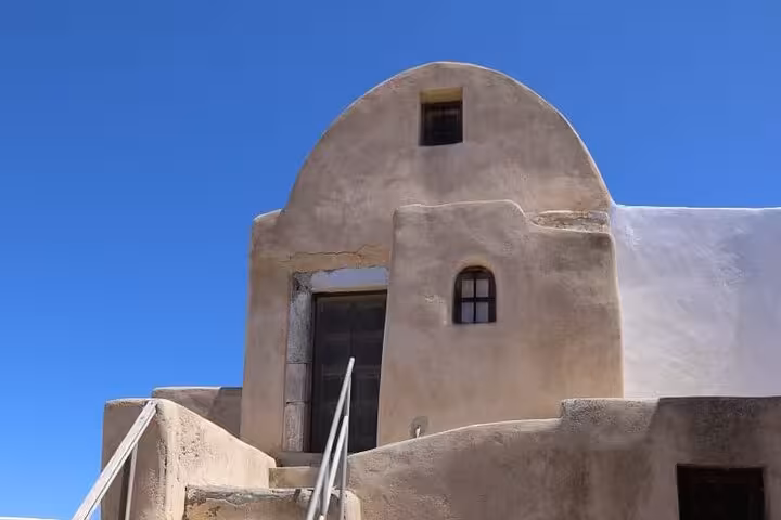 Traditional Santorini cave house facade under clear blue sky, a highlight stop on the One Day Escape to Santorini tour