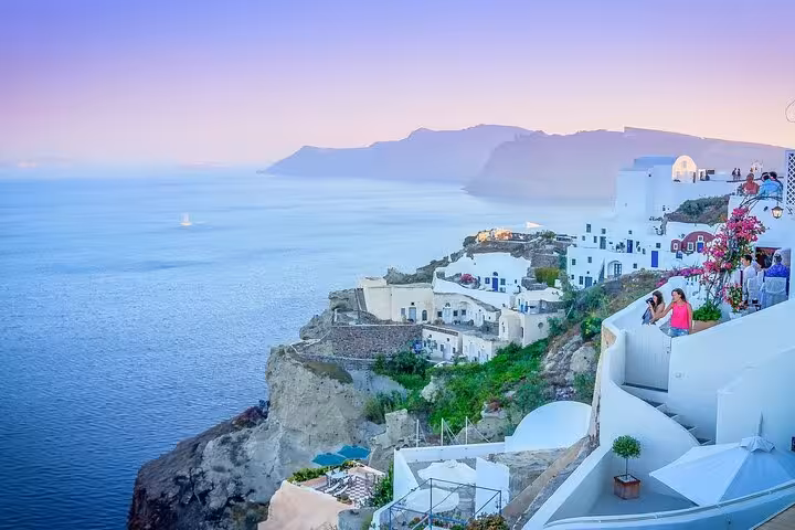 Santorini cliffside villages and caldera sea view at dusk, highlight of 2-day tour from Athens to Mykonos
