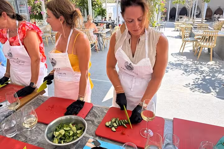 Honeymooners chop fresh Greek salad during Santorini cooking class with winery wine tasting outdoors