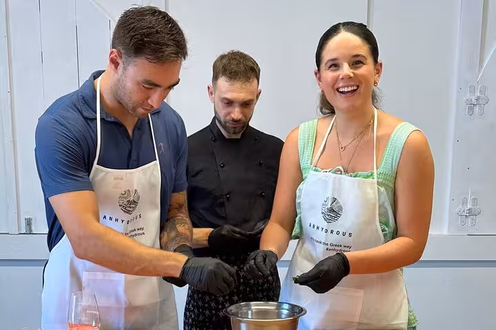 Couple cooking with chef in Santorini class, honeymoon experience with Greek recipes and winery tasting tour