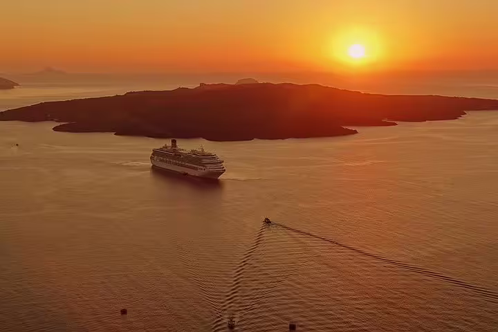 Breathtaking view of a cruise ship sailing near Santorini at sunset, perfect for a private sightseeing tour by night.