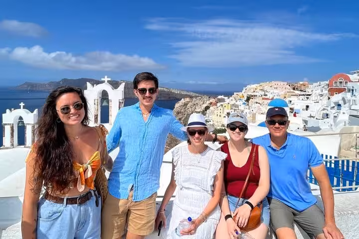 Santorini from Crete day tour with private guide and transfers, group photo in Oia with blue-domed views