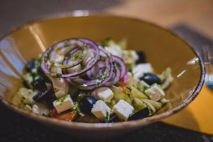 Traditional Greek salad with feta, olives and red onion, served during Santorini caldera view cooking tour