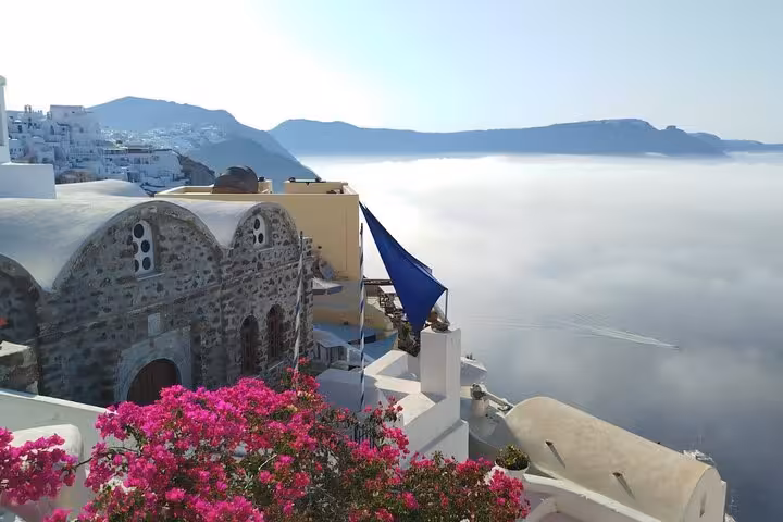 Santorini caldera view from luxury villa terrace with bougainvillea, sea mist and private transport tour