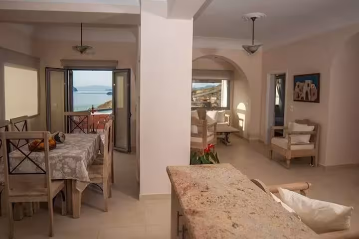 Santorini luxury villa dining and lounge with sea-view balcony, included transport for day getaway tour