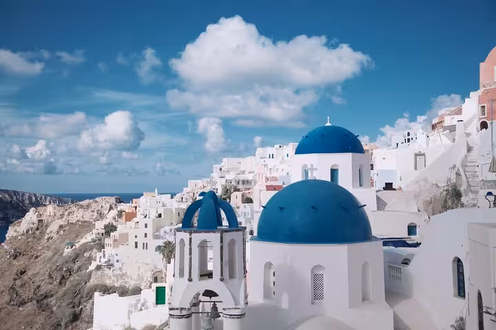 Santorini Oia blue-domed churches overlooking the caldera, highlight of a 7-day private tour from Athens
