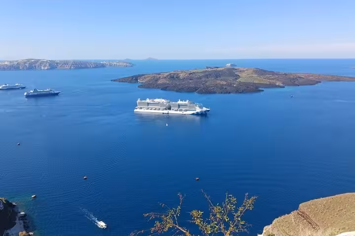 Santorini caldera panorama with cruise ships and volcanic islets, scenic viewpoint on Oia cruise excursion