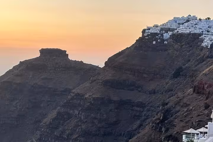 Santorini caldera cliffs at sunset with whitewashed Oia village, scenic cruise ship shore excursion view