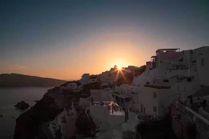 Sunset over Oia’s whitewashed cliffside houses and caldera views on Santorini 3-day private tour from Athens