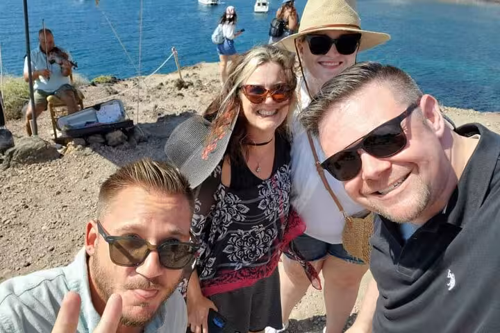 Happy guests on Santorini private tour from Athens by the sea, enjoying sightseeing and wine tasting experience