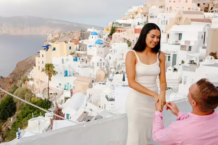 Romantic Santorini proposal in Oia with whitewashed village views, personal wedding photographer capturing