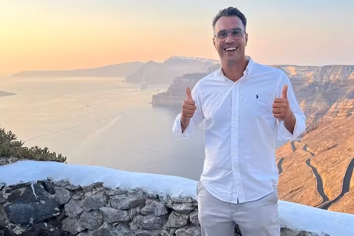 Happy traveler at Santorini caldera sunset viewpoint on wine tasting tour with best views, 2 wineries and tapas