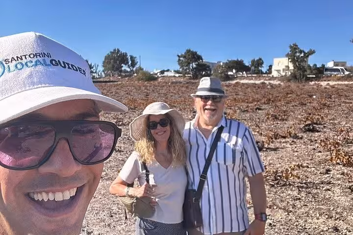 Guests with Santorini local guide on vineyard visit, part of sunset wine tour with two wineries and tapas