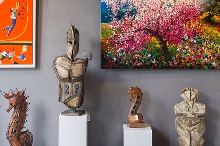 Santorini village art gallery with Cycladic sculptures and colorful paintings on Five Senses wine tour