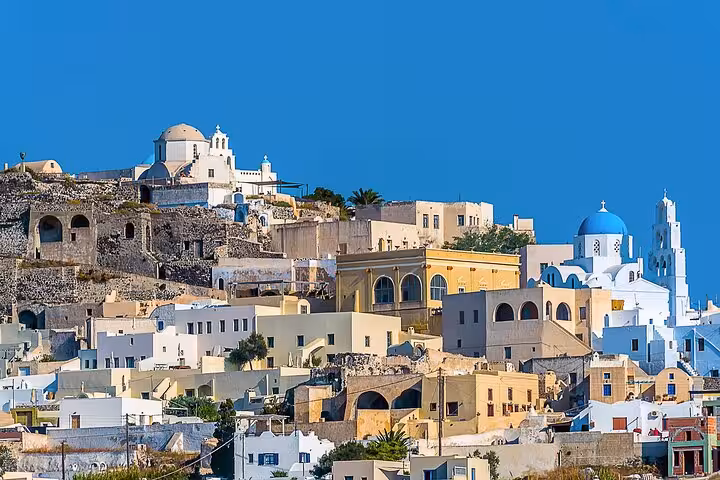 Santorini hillside village with whitewashed homes and blue domes, ideal stop on small-group cruise tour