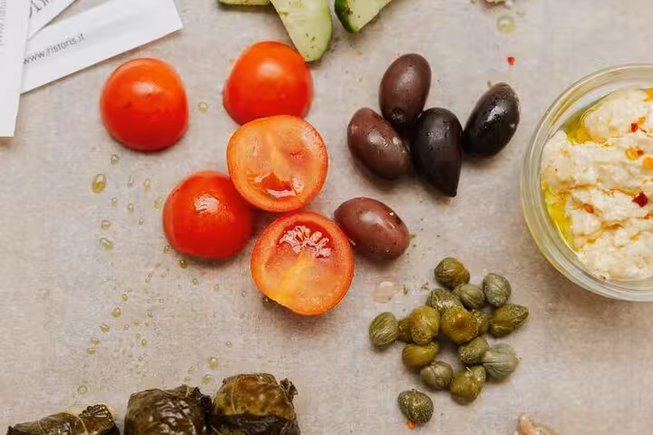 Santorini wine and paint tour mezze spread with tomatoes, olives, capers and feta dip for tasting