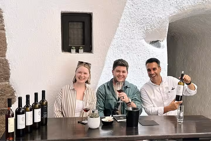 Guests enjoy Santorini wine tasting at a top winery, sampling local reds on a private wine tour