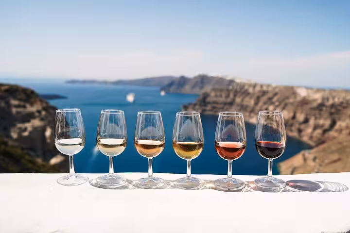 Santorini caldera wine tasting flight at sunset, ideal for Santorini wine and paint adventure tour