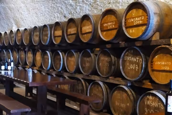 Santorini winery cellar with Vinsanto barrels and tasting table on private tour from Athens wine tasting