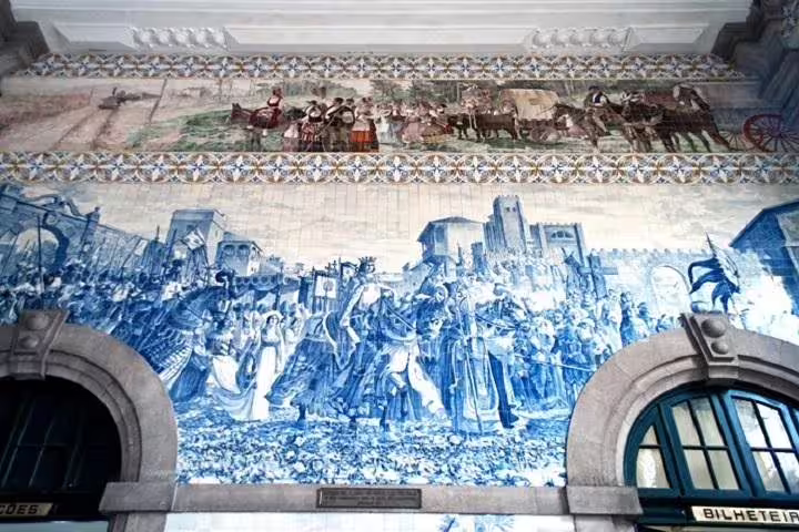 Azulejo murals depicting historical scenes at São Bento Station in Porto, a highlight of the half-day historical tour.